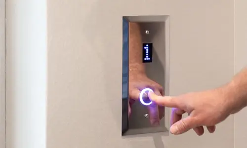 User activating hall call panel button.