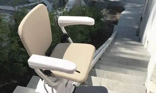 A K2 Straight Stairlift installed outdoors on a cement staircase.