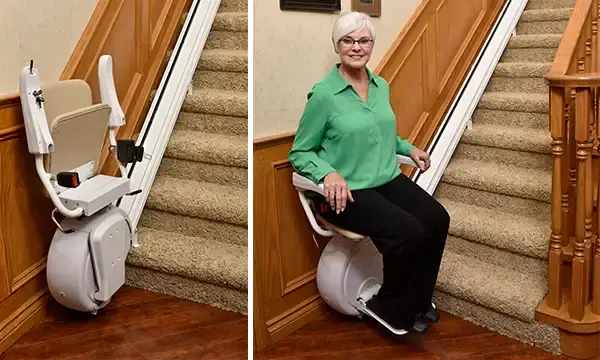 A woman smiling using the Savaria K2 stairlift next to a carpeted staircase.