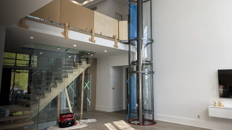 Panoramic winding drum elevator in the process of being installed in a residential home.