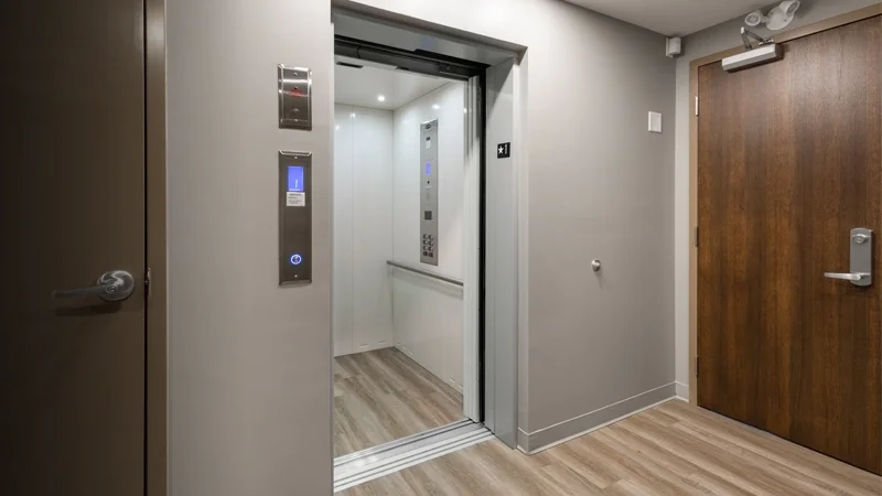White interior cab with gray laminate floor of a LULA elevator.