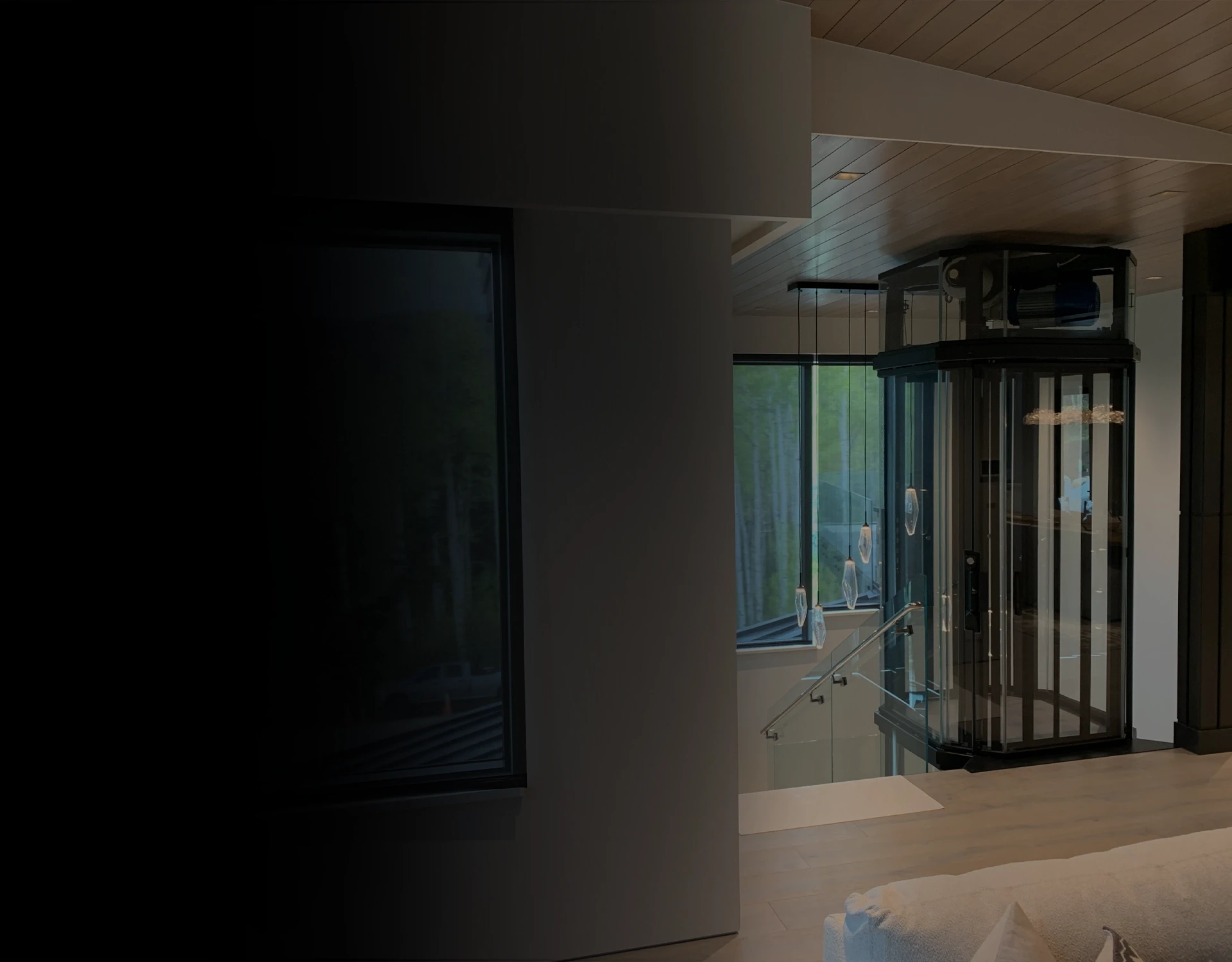 Glass cylindrical residential elevator with panoramic glazing in a modern home interior