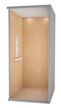 Home elevator interior with light wood panel walls, a white ceiling with recessed lights.