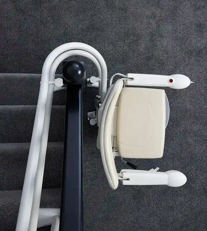 Savaria Handicare 4000 twin-rail curved stairlift with Simplicity Seat, 180-degree parking feature, folded seat and armrests on carpeted stairs viewed from above