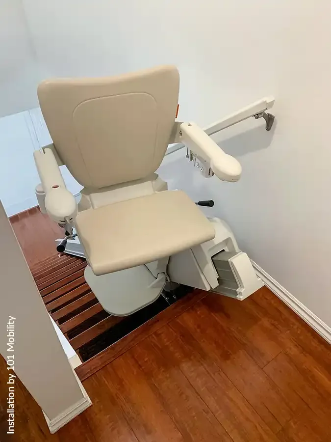 Savaria Handicare 1100 straight stairlift with Style Seat in vanilla beige upholstery, power swivel, multi-drive system with covered rail, and folding footrest at top landing