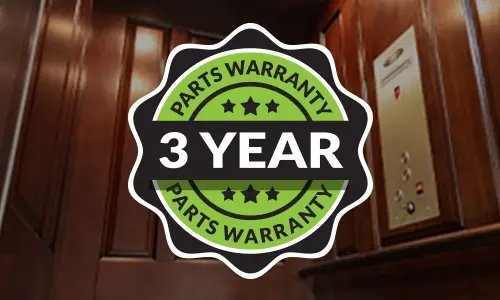 3-year parts warranty badge displayed inside a luxury residential elevator with wood panel walls and control panel.